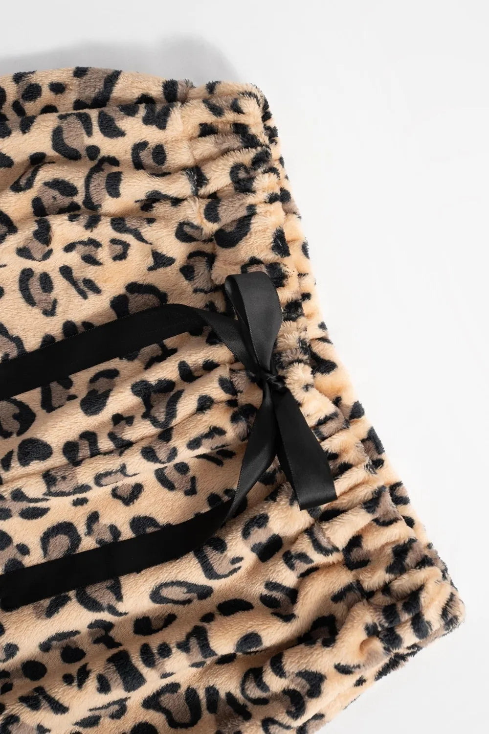 Leopard print backpack with black straps on a white background