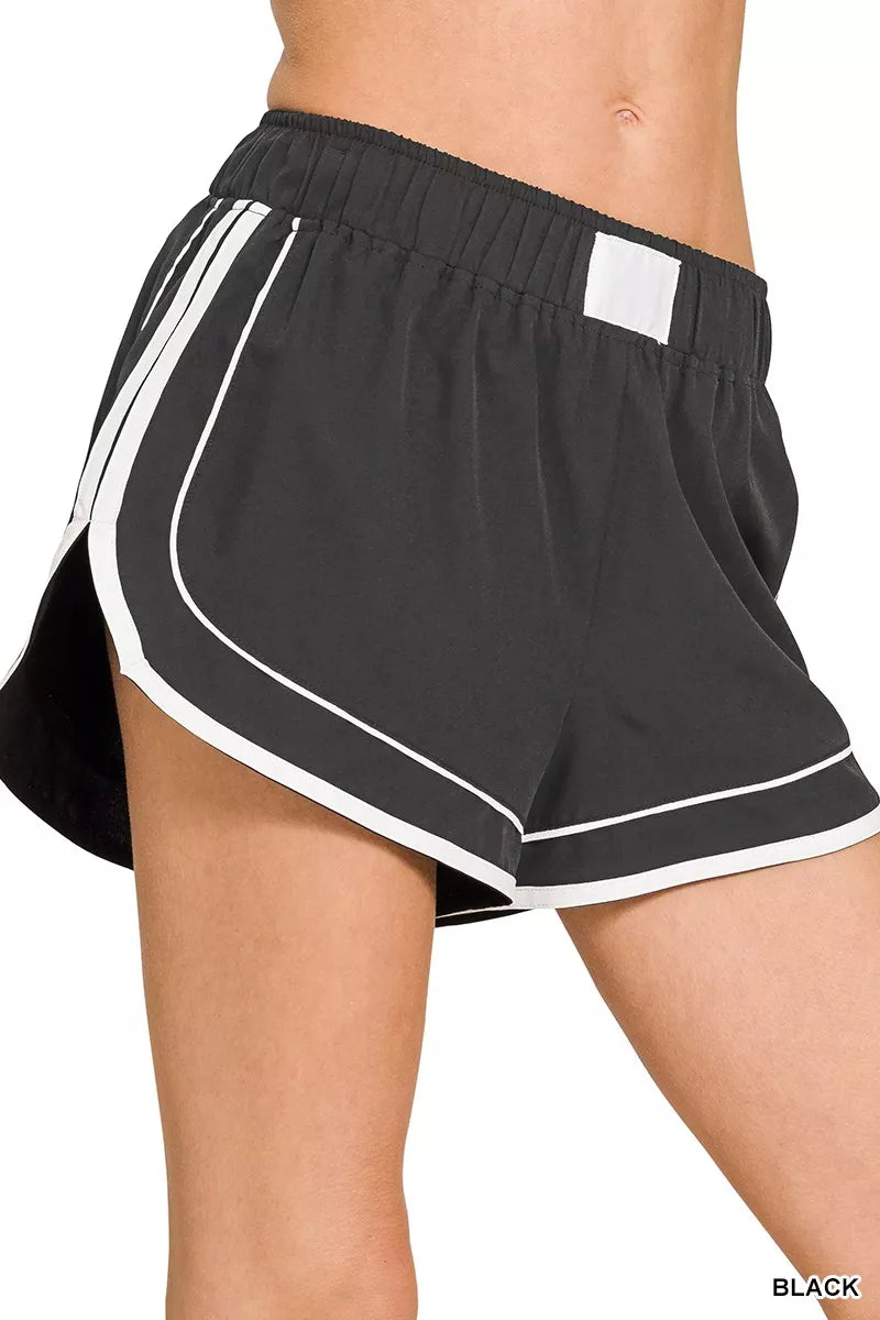 Black athletic shorts with white trim on a white background