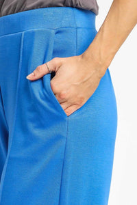 Close-up of blue pants with a hand in the pocket on a white background
