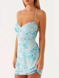 Woman wearing a light blue floral dress on a white background