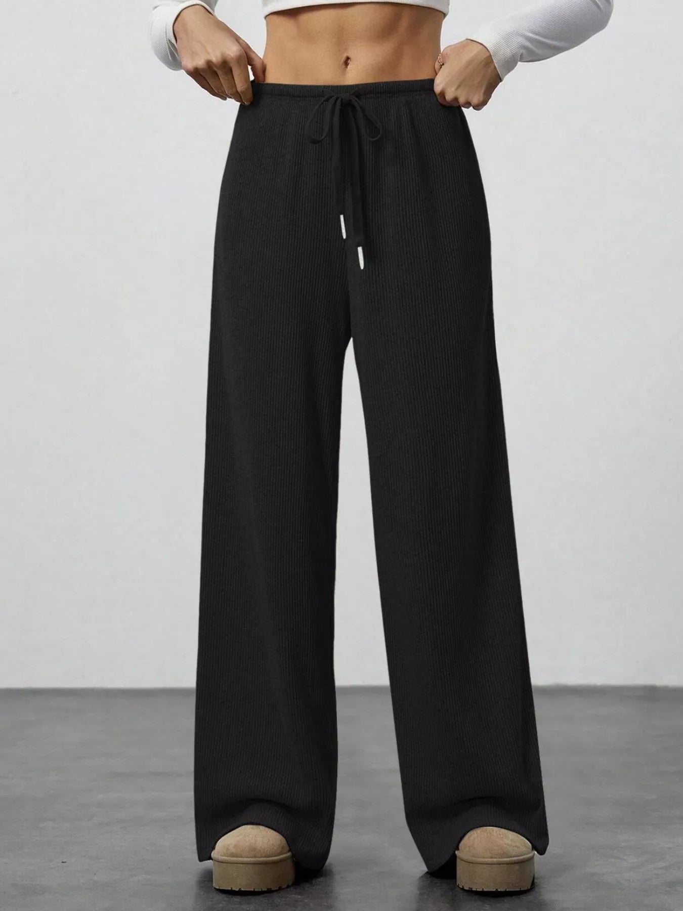 Black wide-leg pants worn by a person on a plain background