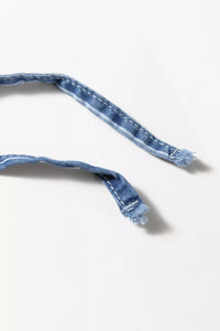 Close-up of a blue denim belt on a white background