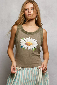 Woman wearing a tank top with a floral design against a plain background