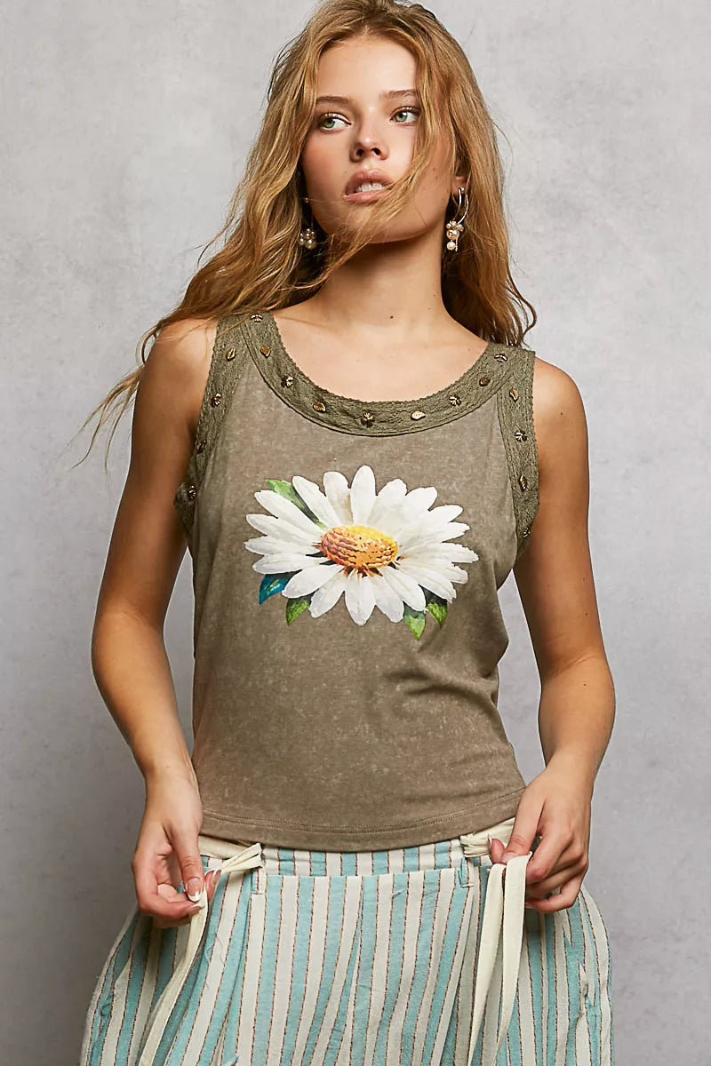 Woman wearing a tank top with a floral design against a plain background