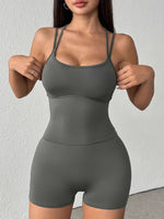 Woman wearing a gray athletic outfit against a white background