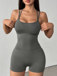 Woman wearing a gray athletic outfit against a white background