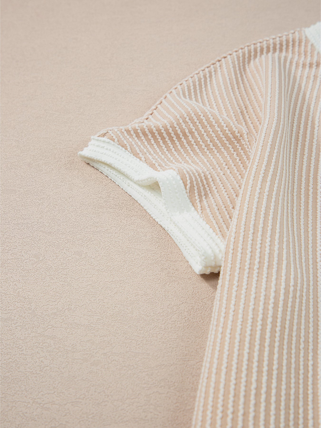 Close-up of a beige and white striped fabric on a beige background