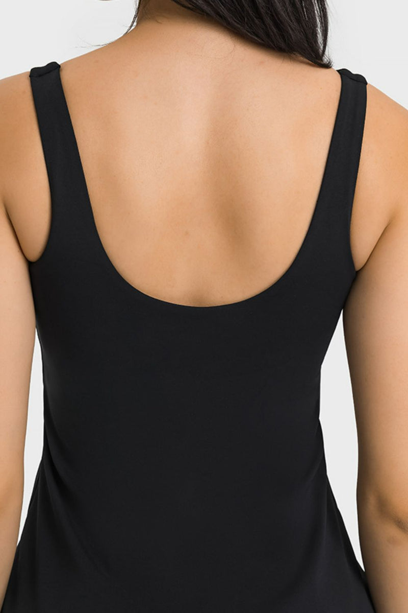 Black sleeveless top worn by a person on a white background