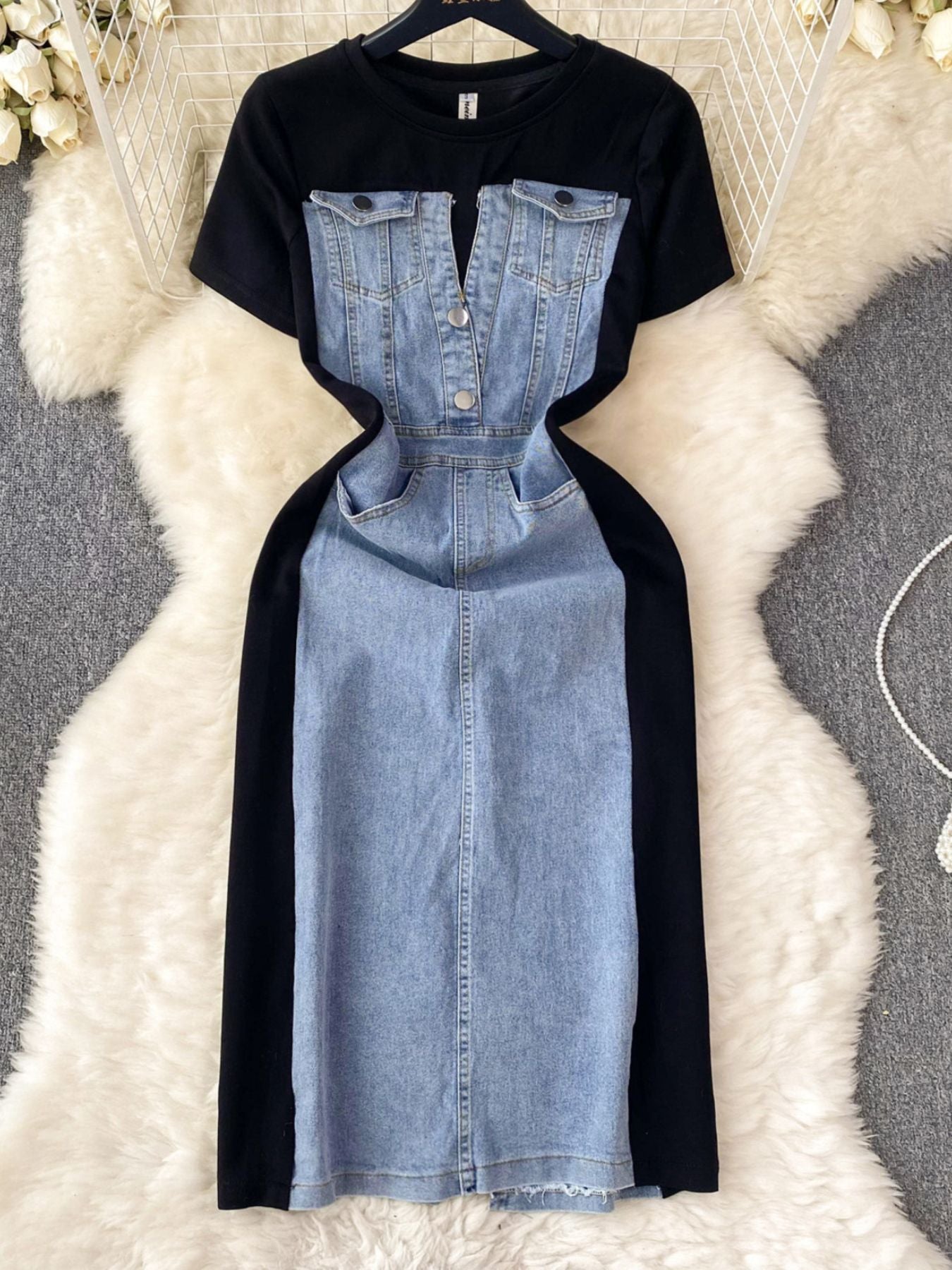 Black t-shirt with denim dress overlay on a textured white surface