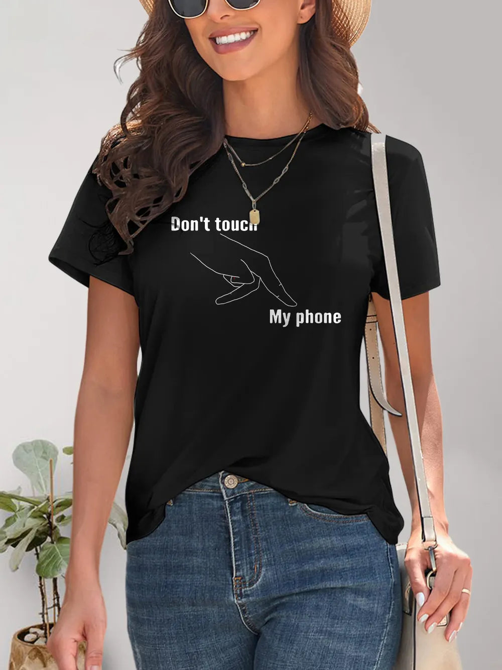 Woman wearing a black t-shirt with 'Don't touch my phone' text.