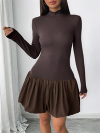 Brown dress with long sleeves and a ruffled skirt on a plain background