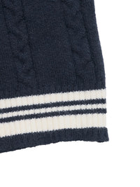 Close-up of a navy blue cable knit sweater with white stripes on a white background