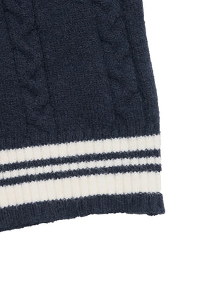 Close-up of a navy blue cable knit sweater with white stripes on a white background