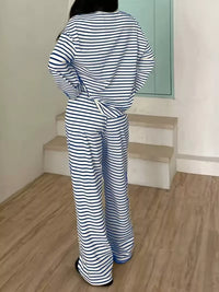Person wearing a blue and white striped outfit standing on a wooden floor.