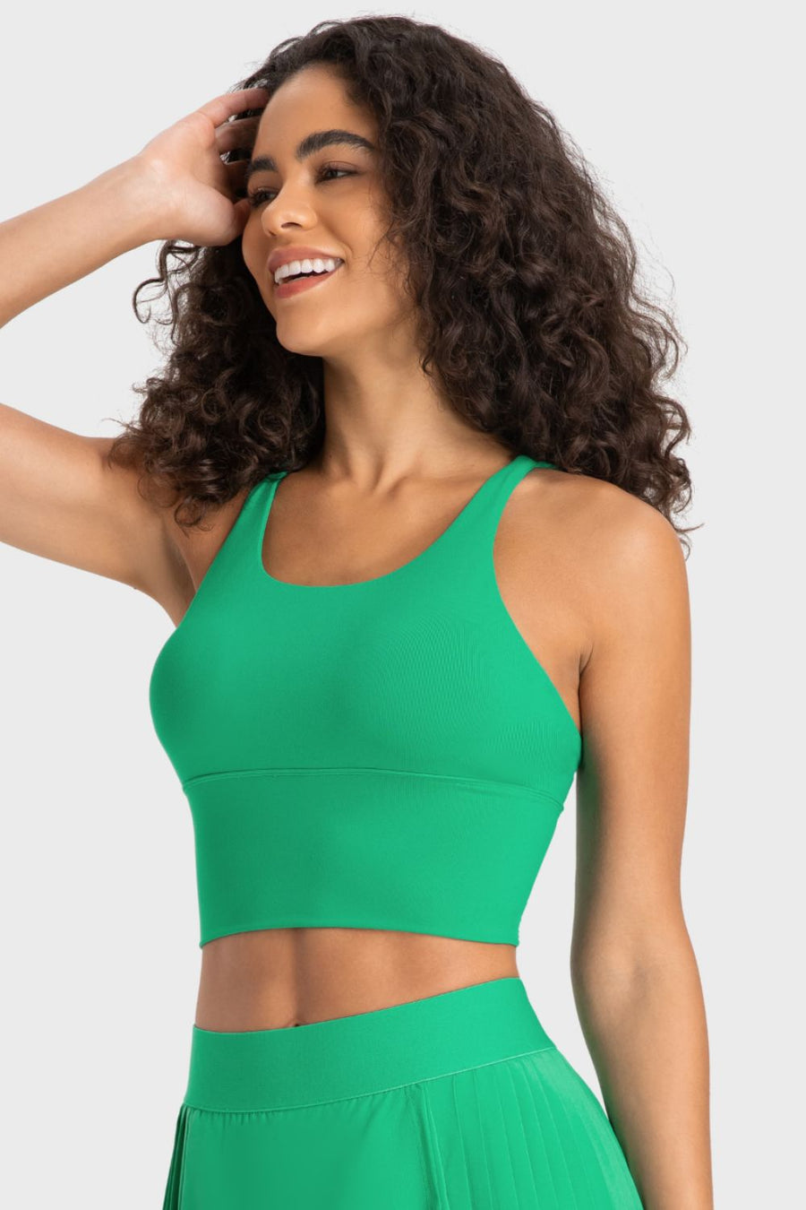 Woman wearing a green athletic outfit against a plain background
