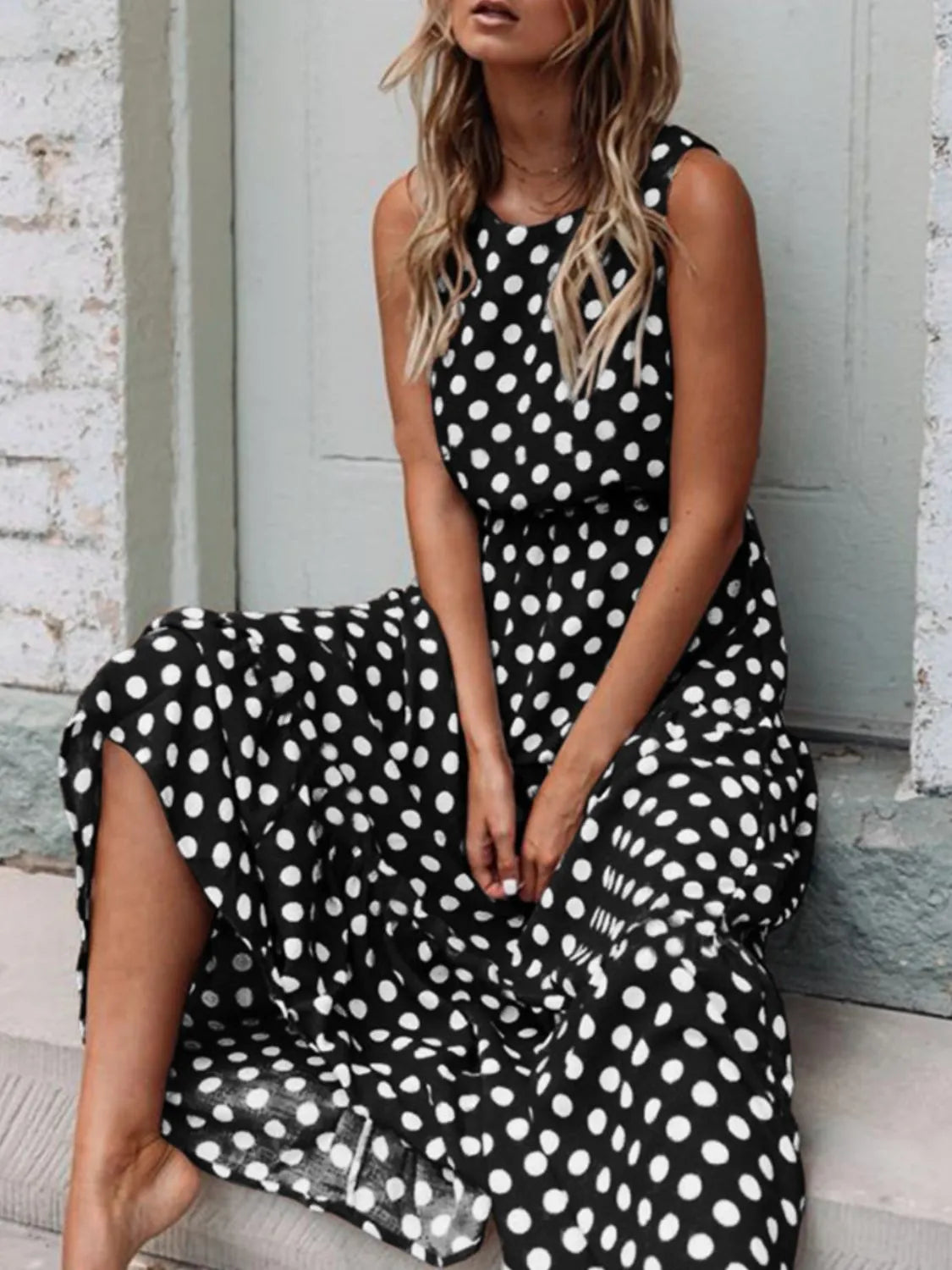Woman sitting on a step wearing Polka Dot Round Neck Sleeveless Midi Dress