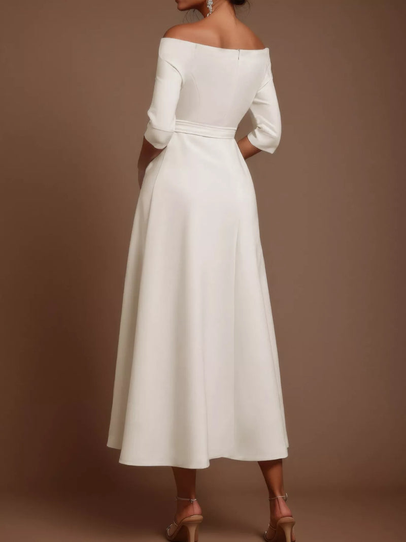 White off-shoulder dress with long sleeves on a brown background