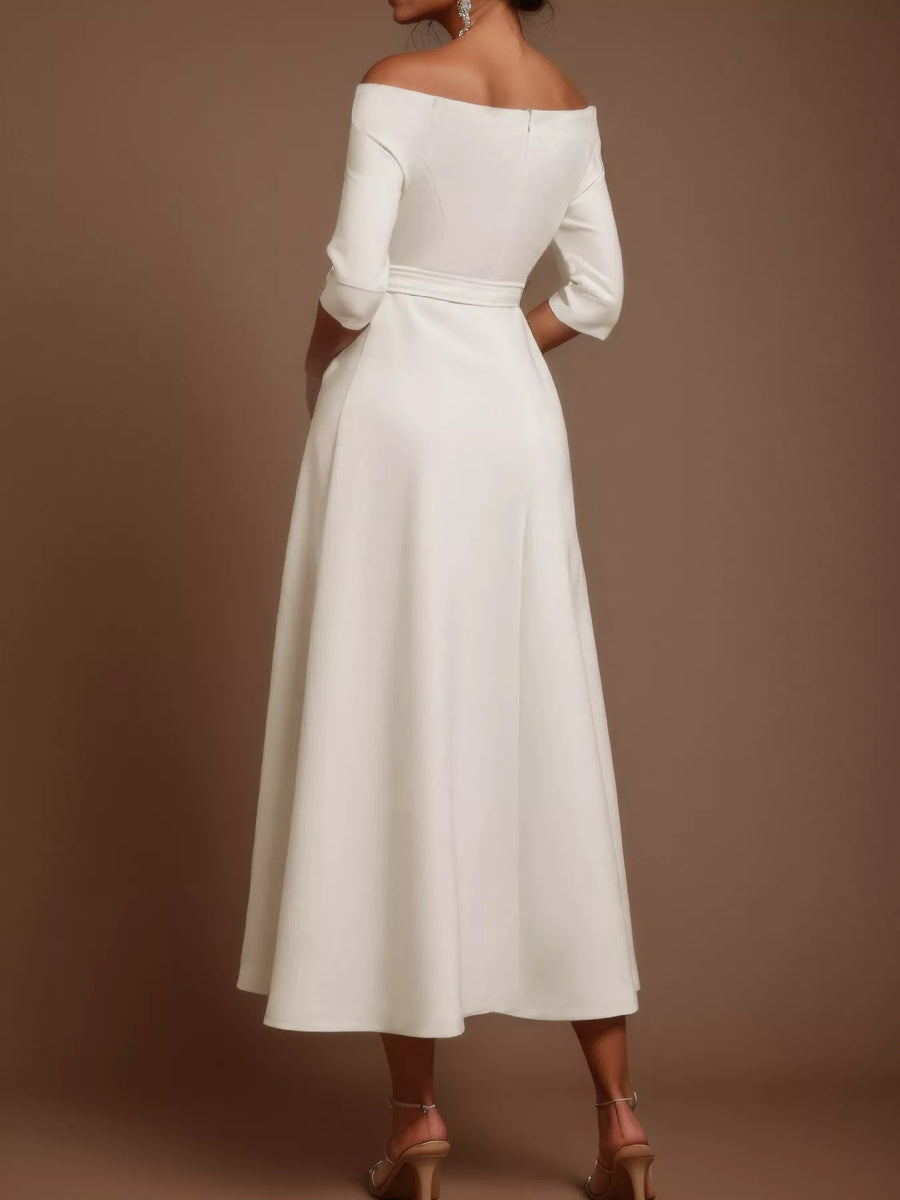 White off-shoulder dress with long sleeves on a brown background