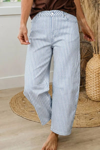 Person wearing blue and white striped pants in a home setting.