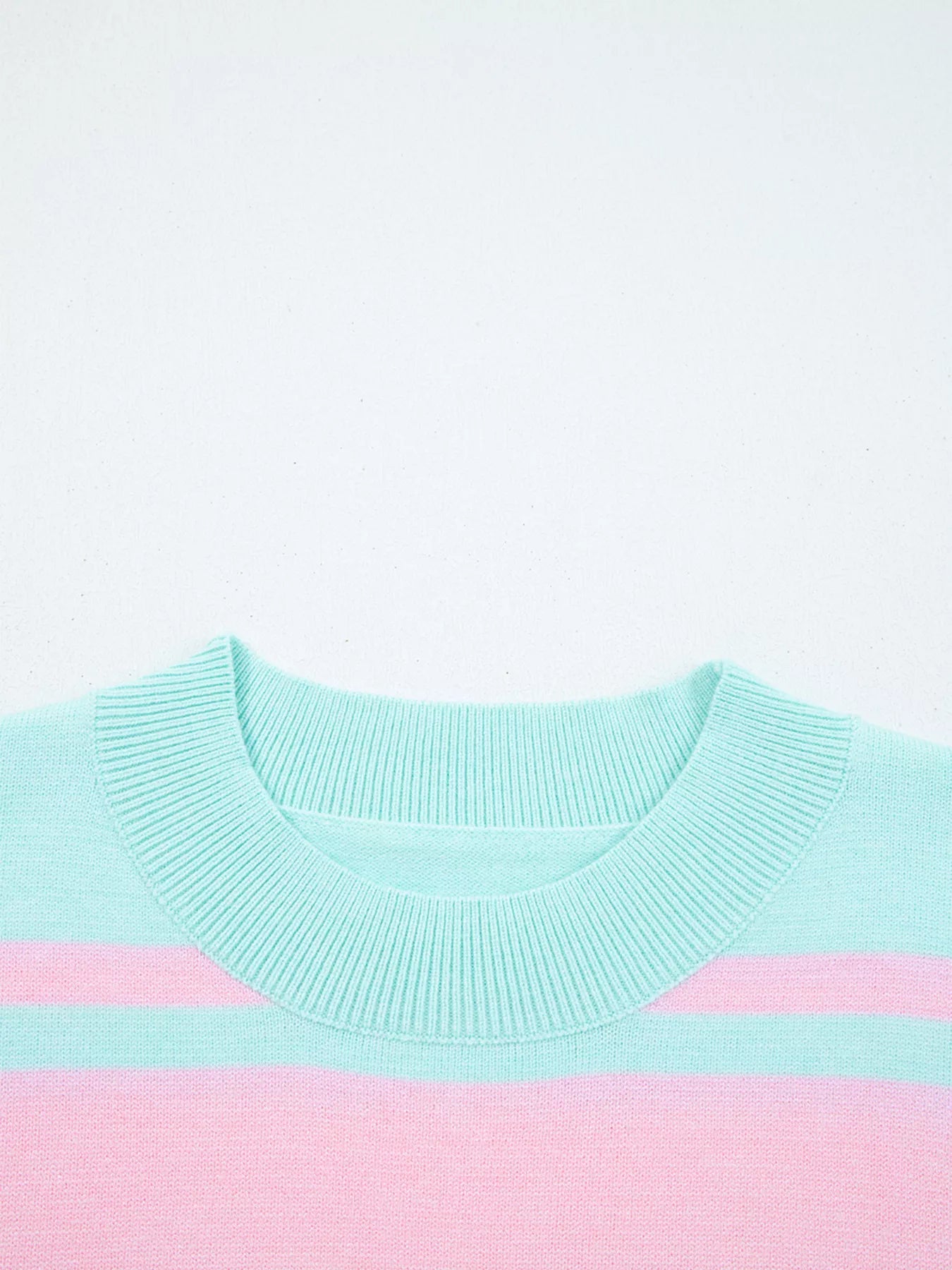Light blue and pink sweater on a white background