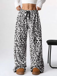 Leopard print pants worn by a person on a white background