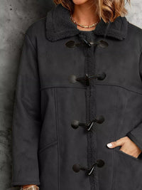 Black duffle coat with black buttons on a textured gray background