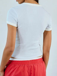 Person wearing a white crop top and red shorts on a plain background