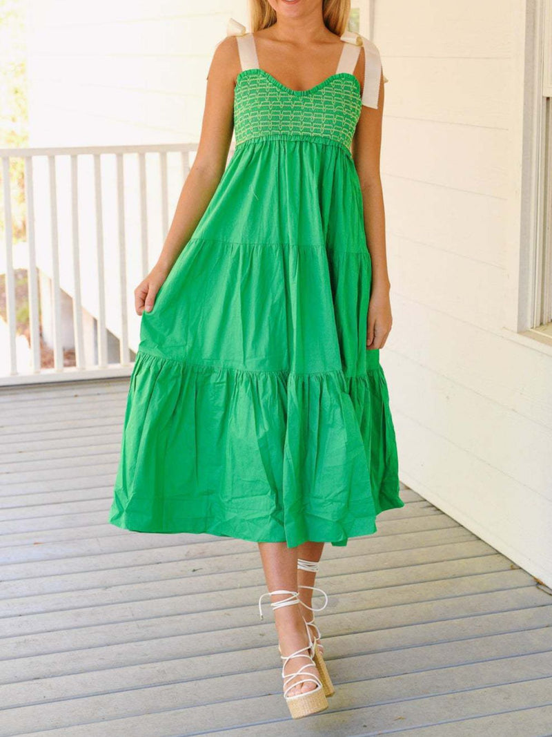 Woman wearing a green dress on a wooden deck
