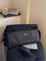 Black and gray bag with 'Dior' branding on a chair