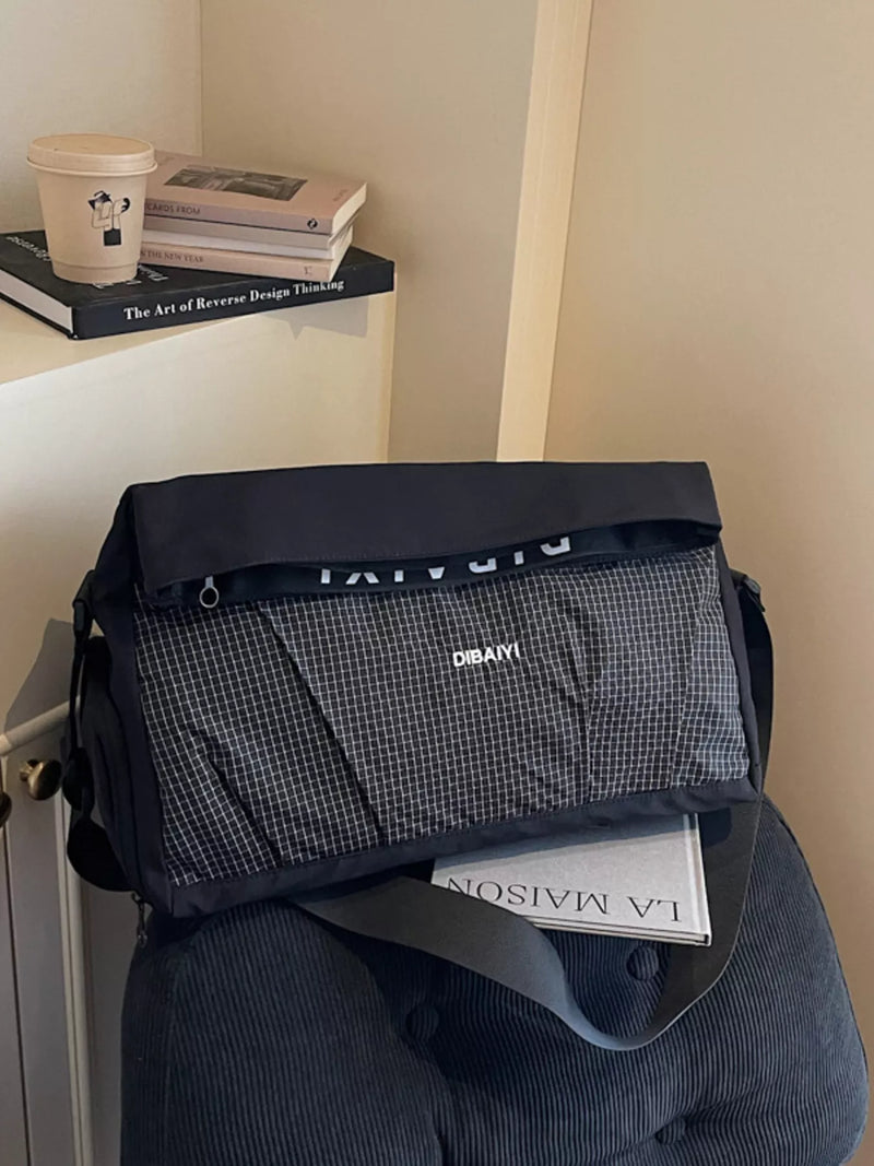Black and gray bag with 'Dior' branding on a chair