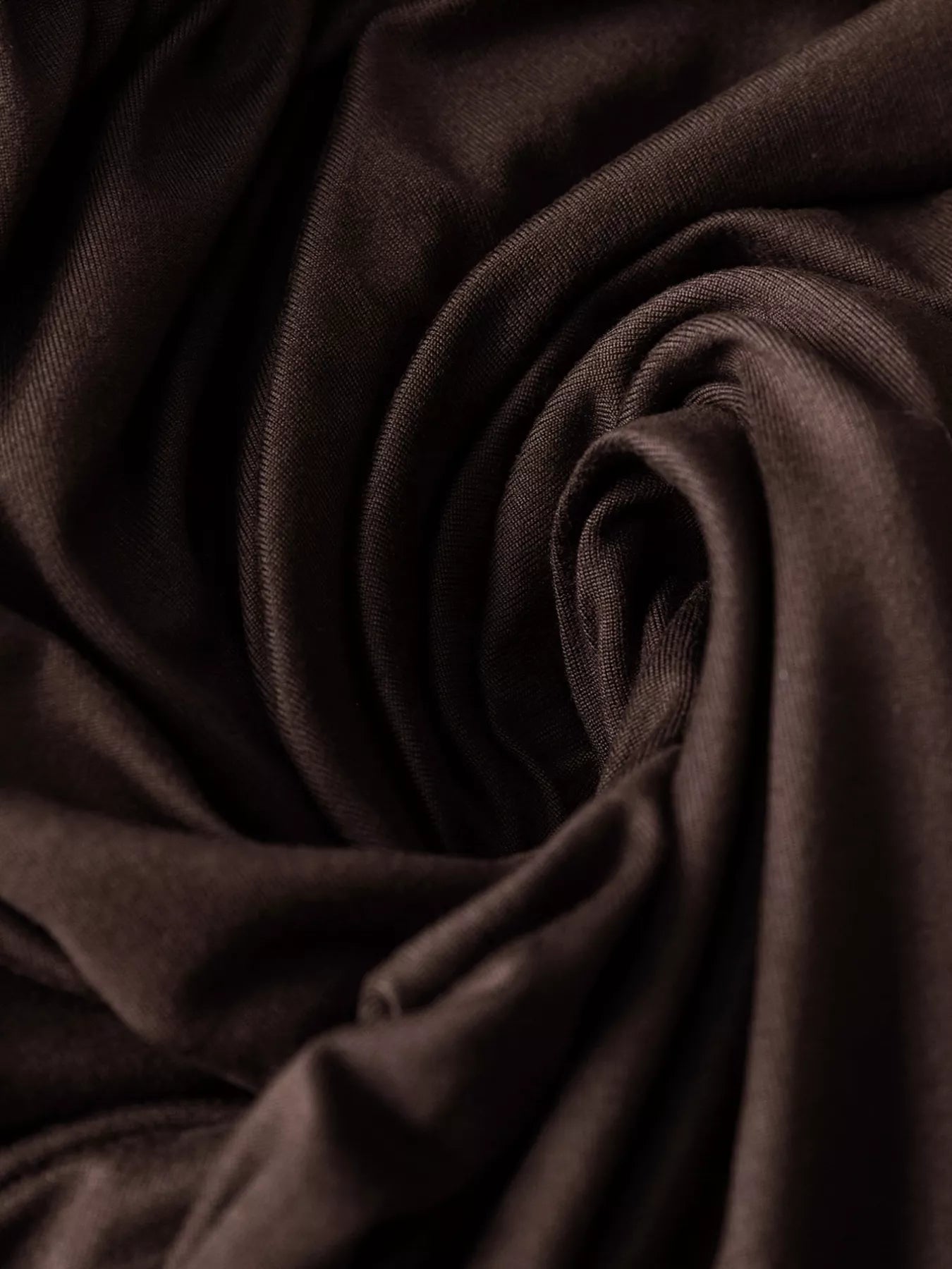 Close-up of dark brown fabric with folds
