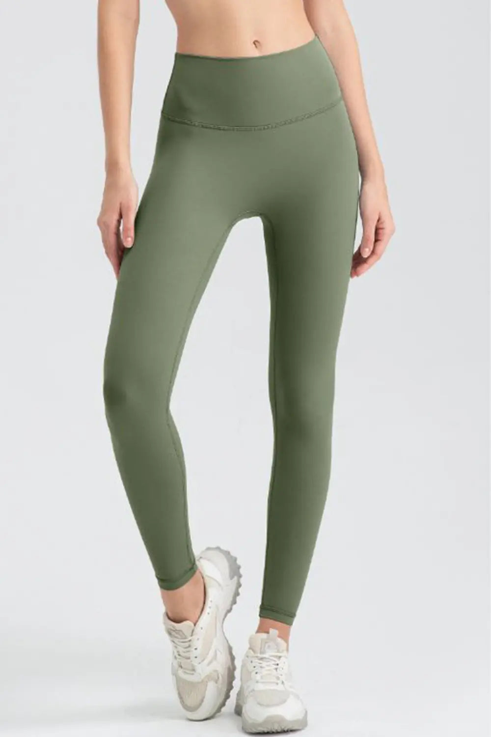 Person wearing green leggings on a white background