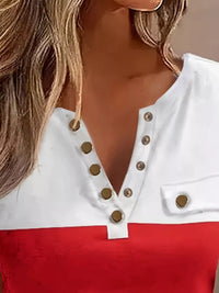 Close-up of a white top with gold buttons and red fabric, worn by a person.