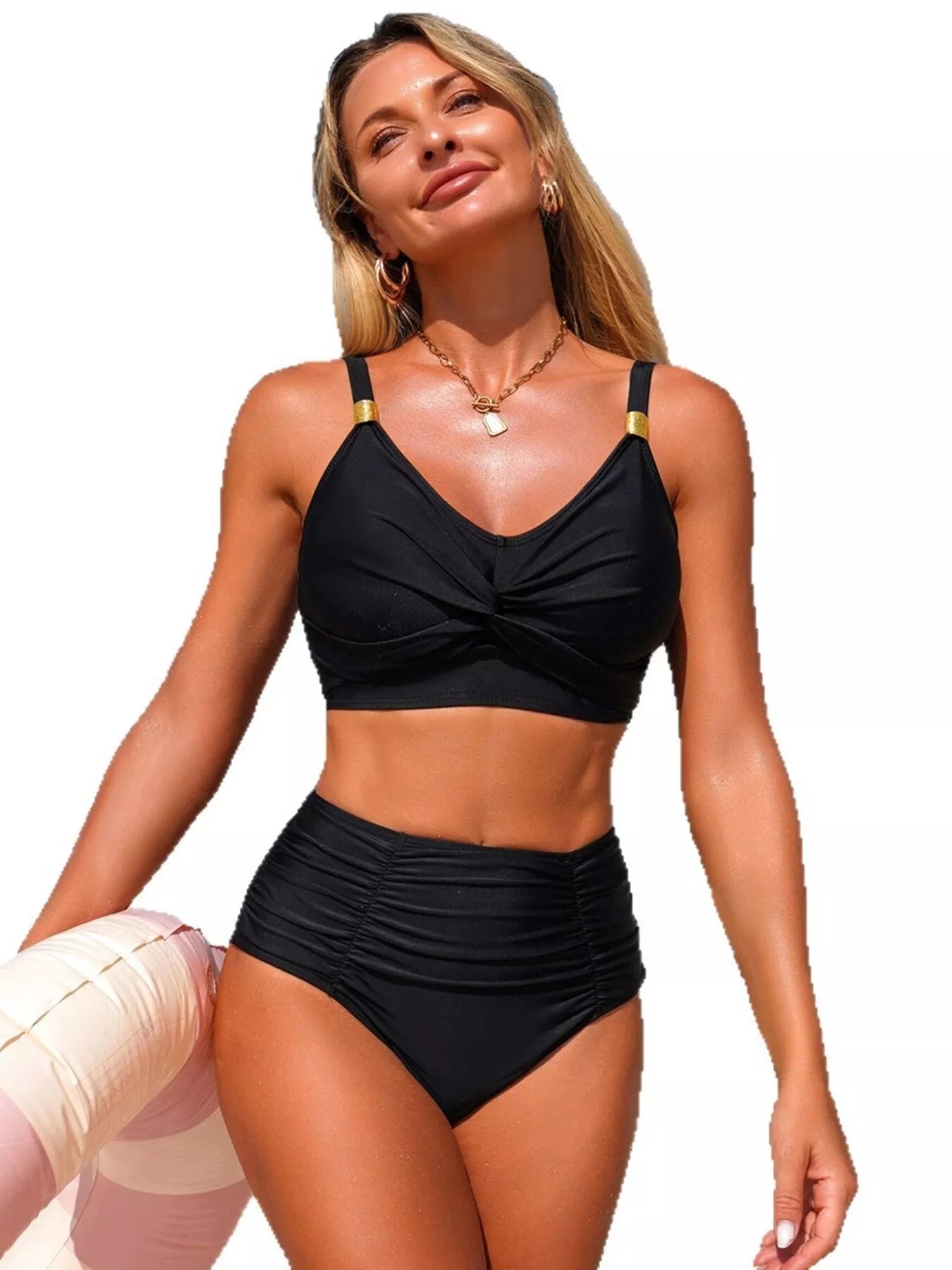 Woman wearing a black bikini with gold straps on a white background