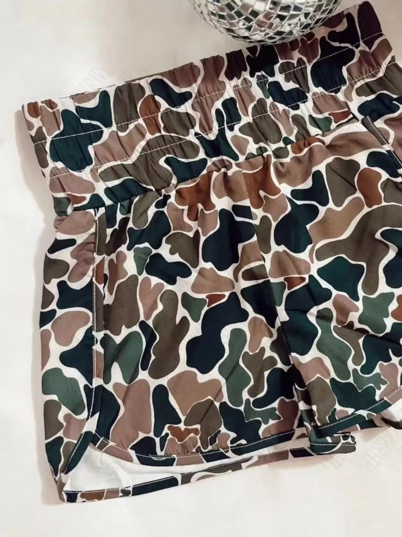 Camouflage-patterned shorts on a white surface