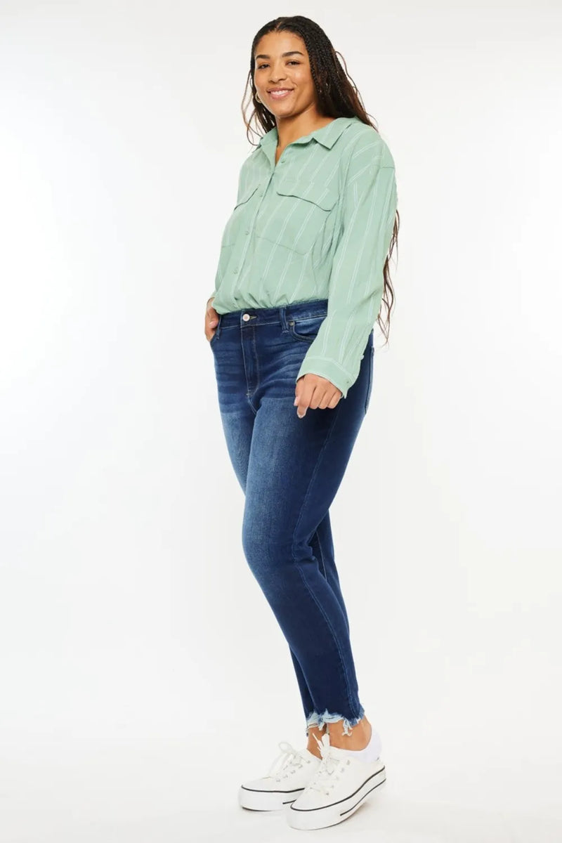 Woman wearing a light green shirt and blue jeans on a white background