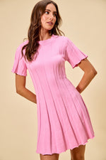 Woman wearing a pink dress against a beige background