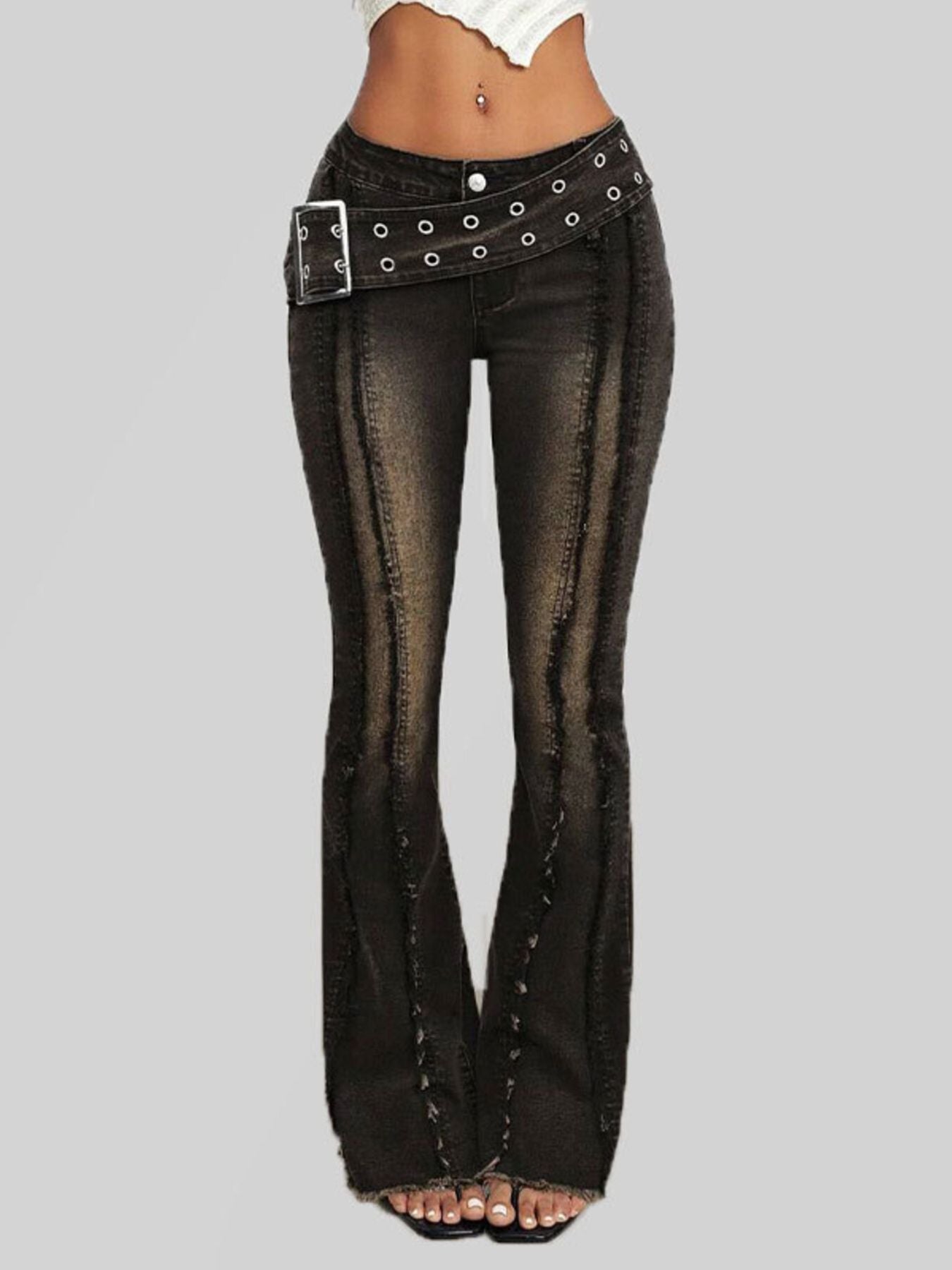 Black flared jeans with studded details on a gray background