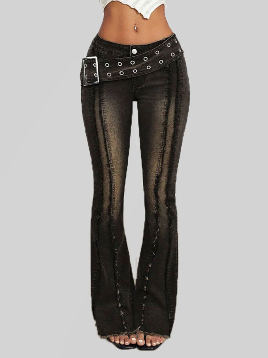 Black flared jeans with studded details on a gray background