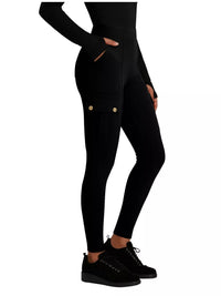 Black leggings with gold buttons worn by a person on a white background