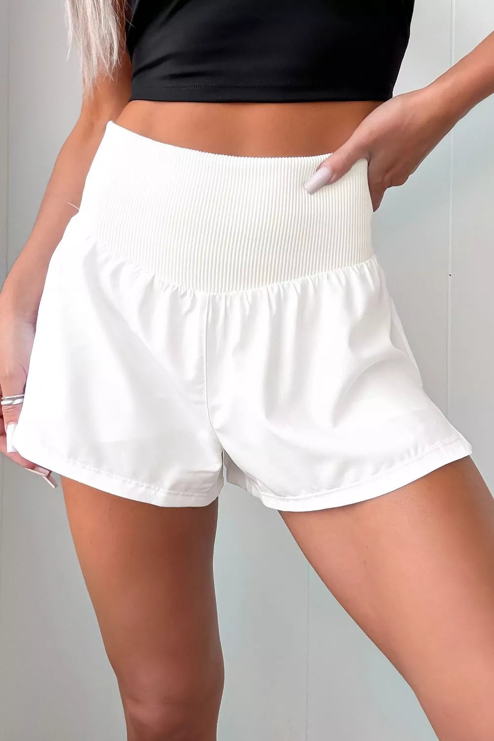 White shorts worn by a person against a neutral background