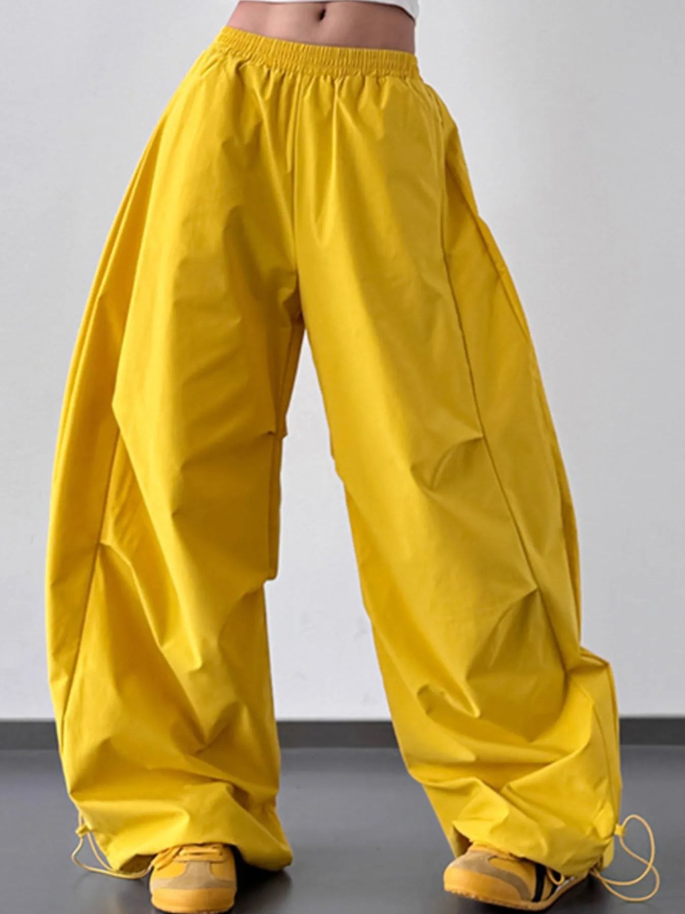 Yellow wide-leg pants worn by a person on a plain background