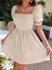 Beige dress with puff sleeves worn by a person outdoors.