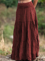 Brown tiered skirt worn by a person standing outdoors with a blurred natural background