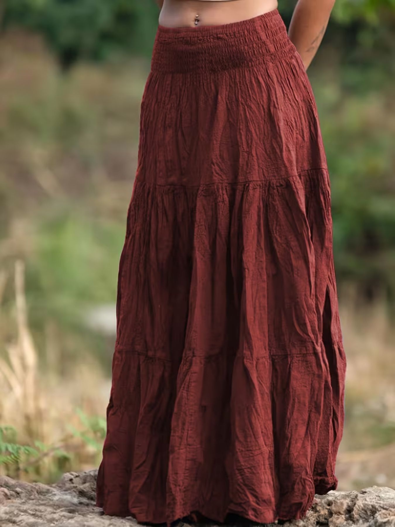 Brown tiered skirt worn by a person standing outdoors with a blurred natural background