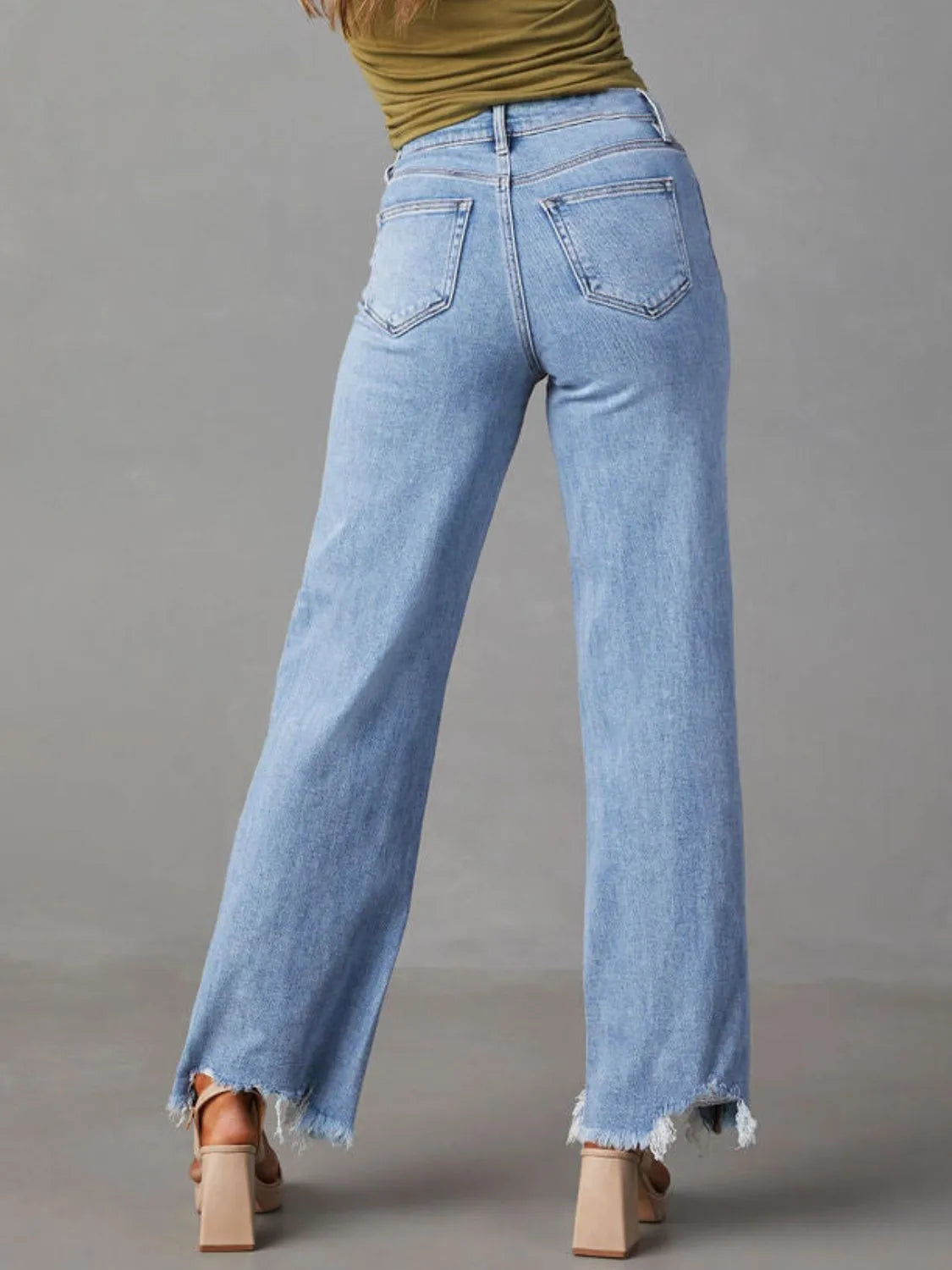 Light blue jeans worn by a person on a gray background