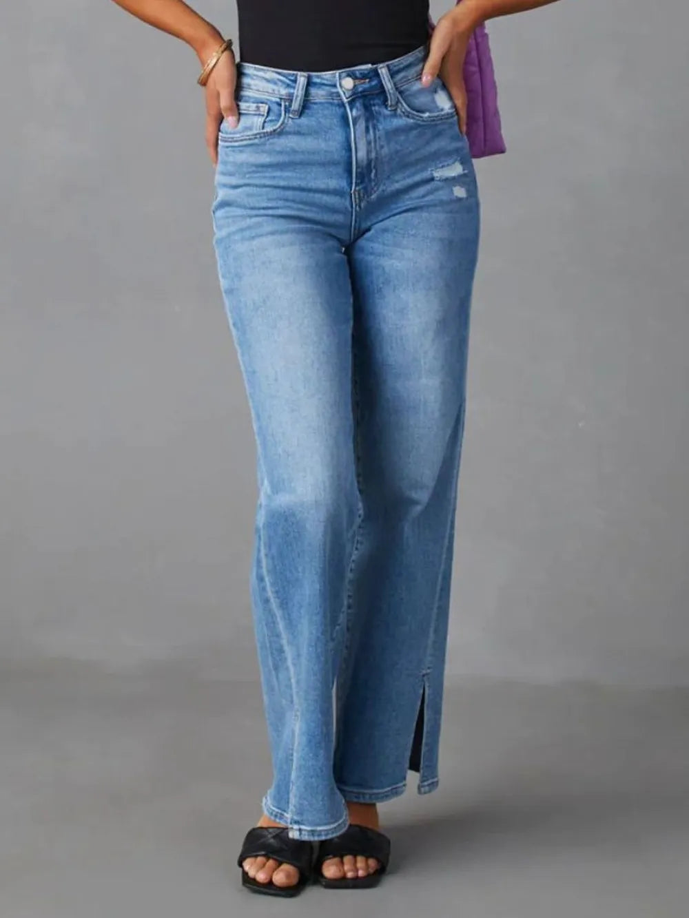 Person wearing blue jeans on a gray background