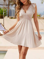 Woman in a white dress standing by a pool with a scenic background
