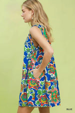 Woman wearing a colorful floral dress against a light green background