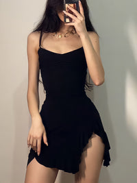 Person wearing a black dress against a plain background